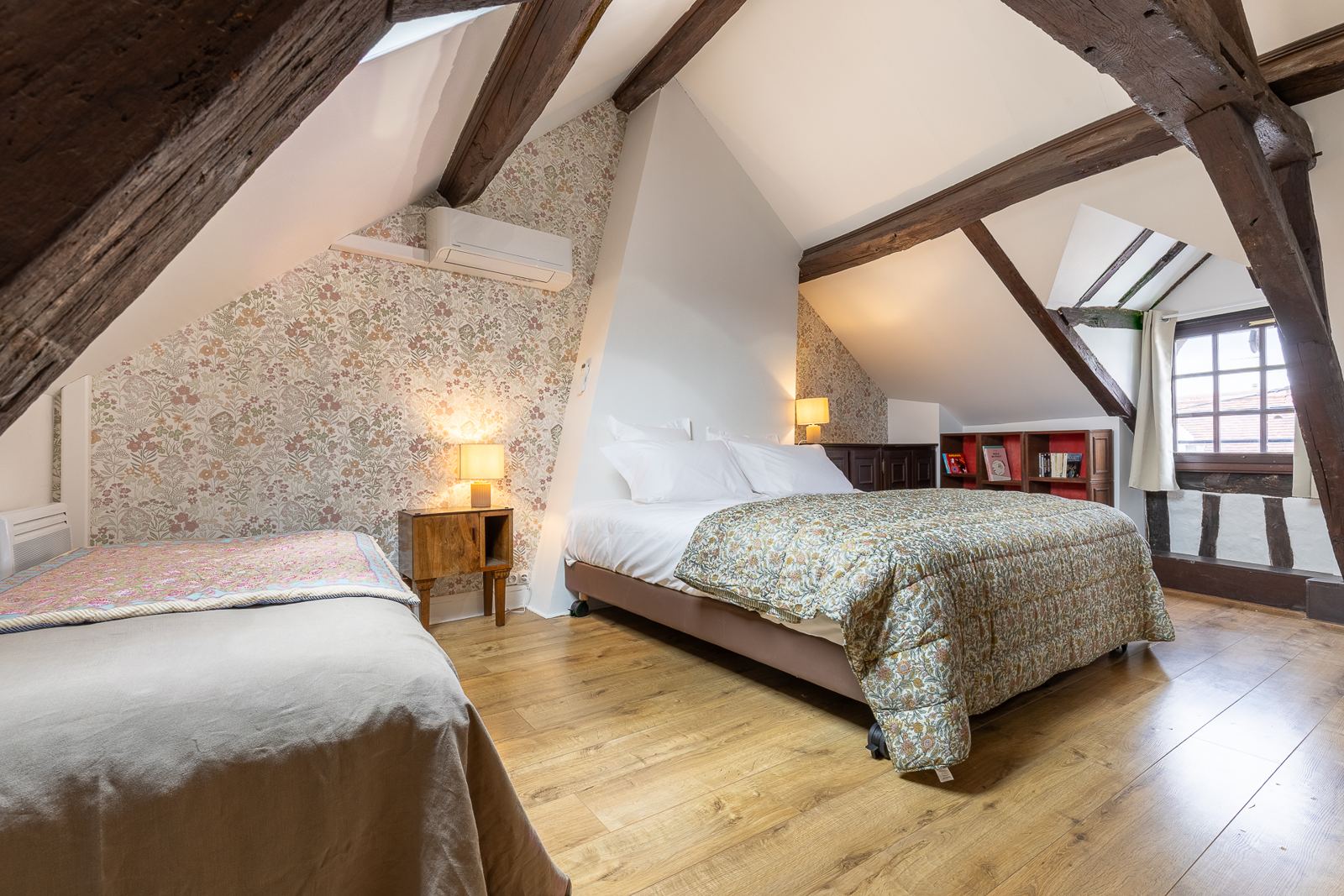 La chambre sous les toits : charpente apparente, lit double et lit simple, papier peint fleuri