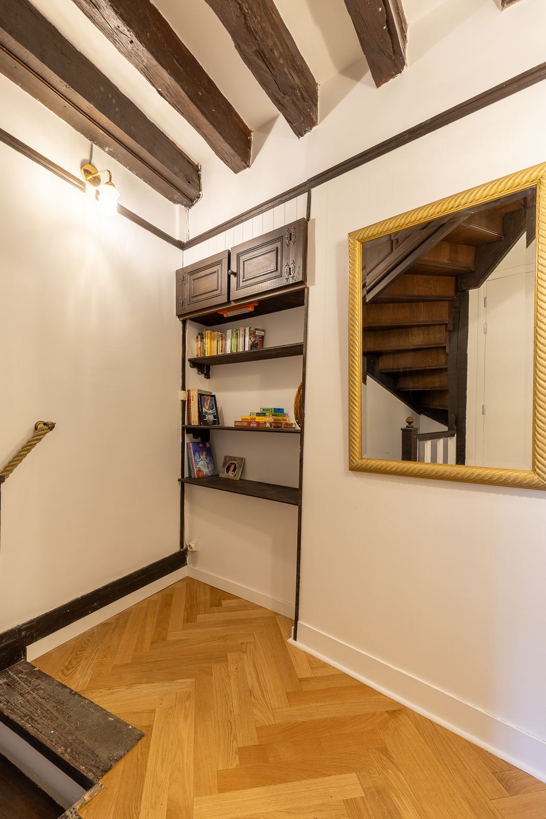 Palier avec bibliothèque, jeux et grand miroir doré
